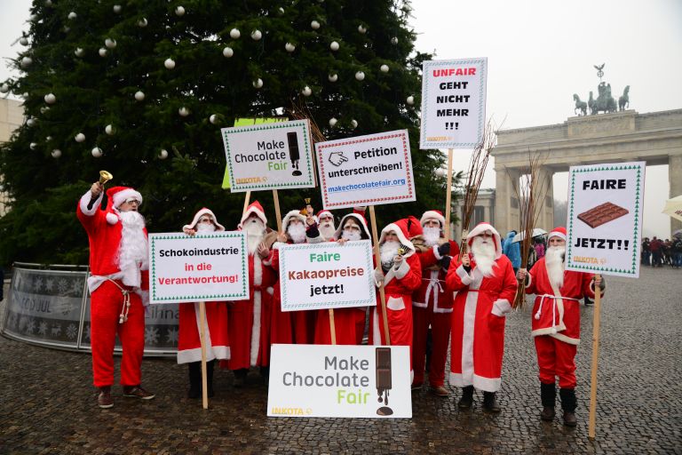 Weihnachtsmänner der Kampagne "Make Chocolate Fair!" streiken 2014 vor dem Brandenburger Tor in Berlin